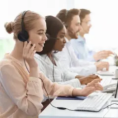 Équipe au bureau des aides régionales, en plein démarchage téléphonique. Ils sont souriants et concentrés sur leurs ordinateurs.