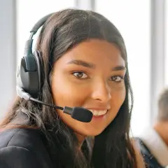 Une opératrice souriante, casque sur les oreilles, prête pour le démarchage téléphonique 06.