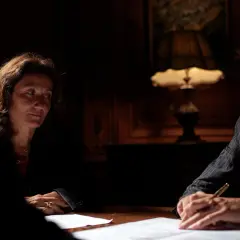 Trois personnes discutent autour d'une table. La question : combien de temps peut-on bloquer une succession ? L'ambiance est sérieuse.