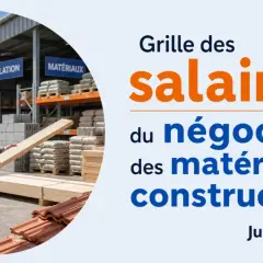 Un homme examine du bois dans un entrepôt de matériaux de construction. La grille des salaires du négoce des matériaux de construction est affichée.