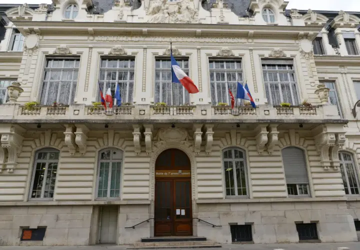 Mairie du 7ème arrondissement, avec drapeaux français. Si vous vous demandez combien de temps pour déclarer un décès, ce bâtiment est un lieu où trouver des informations.