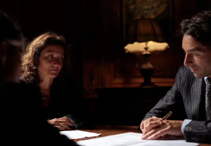 Trois personnes discutent autour d'une table. La question : combien de temps peut-on bloquer une succession ? L'ambiance est sérieuse.