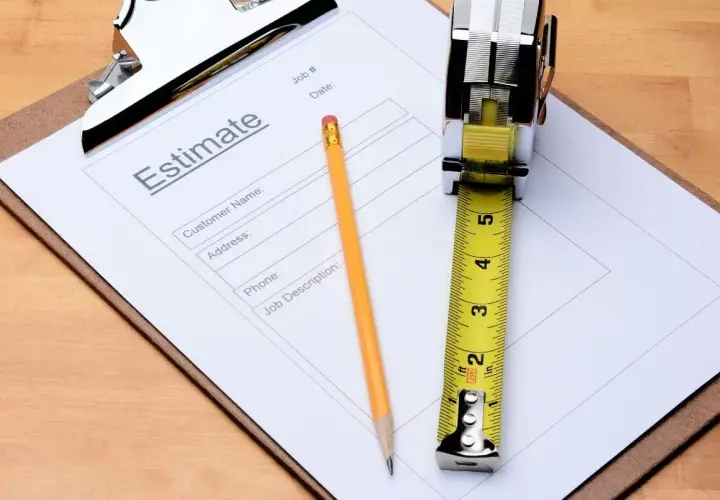 Un devis, un crayon et un mètre ruban sur un presse-papiers. Une scène évoquant le non-respect du devis par le professionnel.