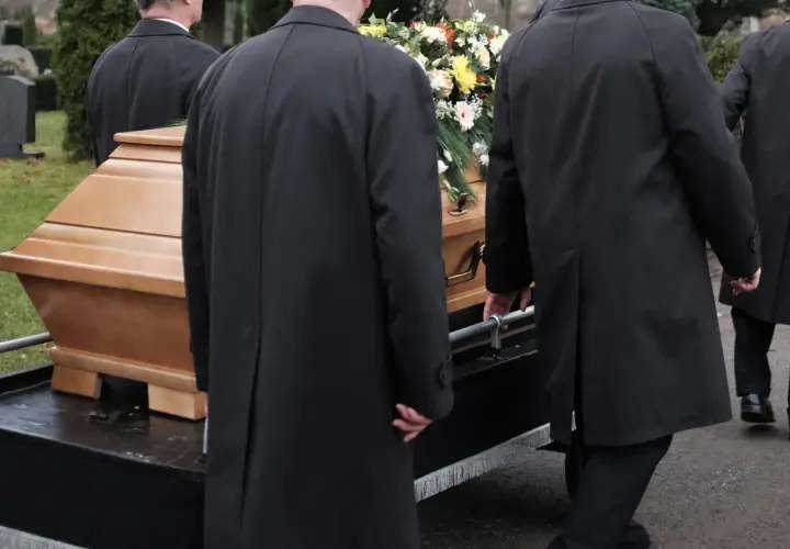 Porteurs en manteaux noirs transportent un cercueil fleuri. La question "peut on être enterré dans son jardin" résonne.