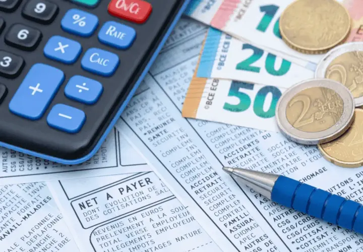 Calculatrice, billets et pièces en euros sur un bulletin de paie. Idéal pour le calcul ancienneté.