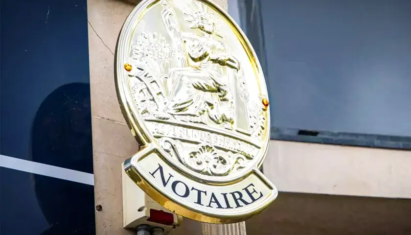 Plaque dorée "NOTAIRE" sur un mur. Une image qui pourrait évoquer un détournement d'héritage par notaire, une affaire sombre.
