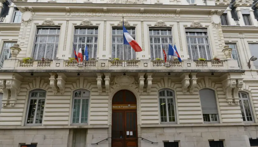 Mairie du 7ème arrondissement, avec drapeaux français. Si vous vous demandez combien de temps pour déclarer un décès, ce bâtiment est un lieu où trouver des informations.