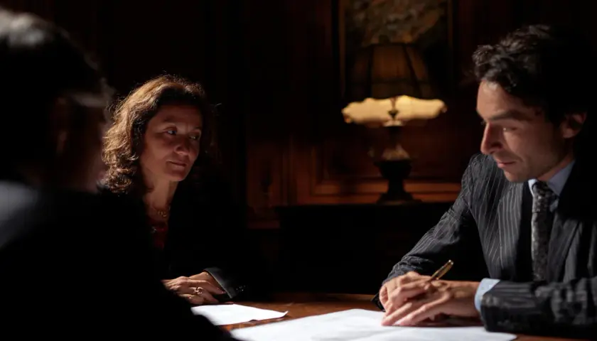 Trois personnes discutent autour d'une table. La question : combien de temps peut-on bloquer une succession ? L'ambiance est sérieuse.