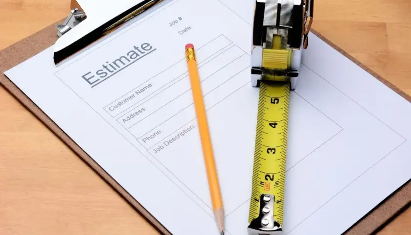 Un devis, un crayon et un mètre ruban sur un presse-papiers. Une scène évoquant le non-respect du devis par le professionnel.