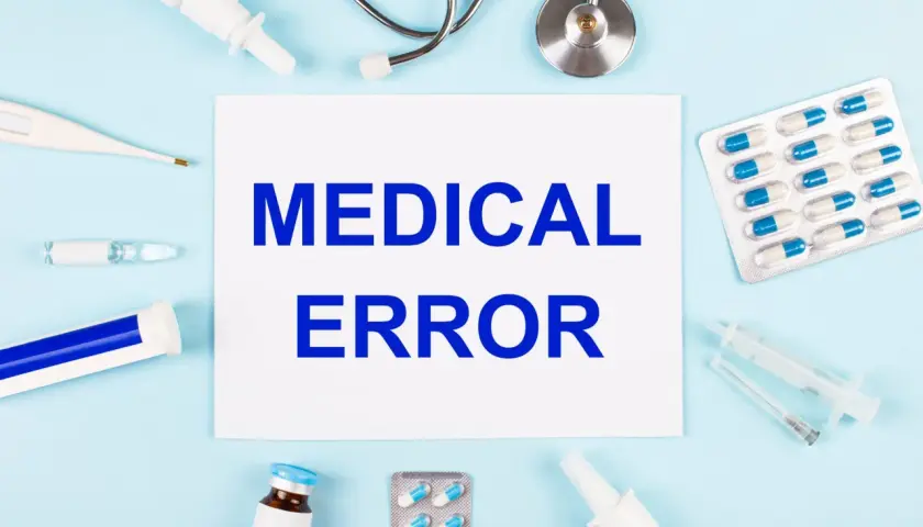 Papier avec "MEDICAL ERROR" entouré de matériel médical. Une situation qui peut mener à dénoncer un médecin.