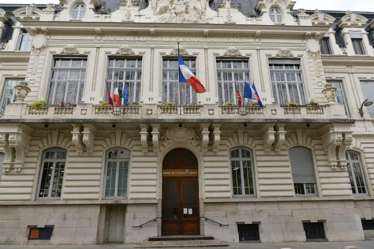 Mairie du 7ème arrondissement, avec drapeaux français. Si vous vous demandez combien de temps pour déclarer un décès, ce bâtiment est un lieu où trouver des informations.
