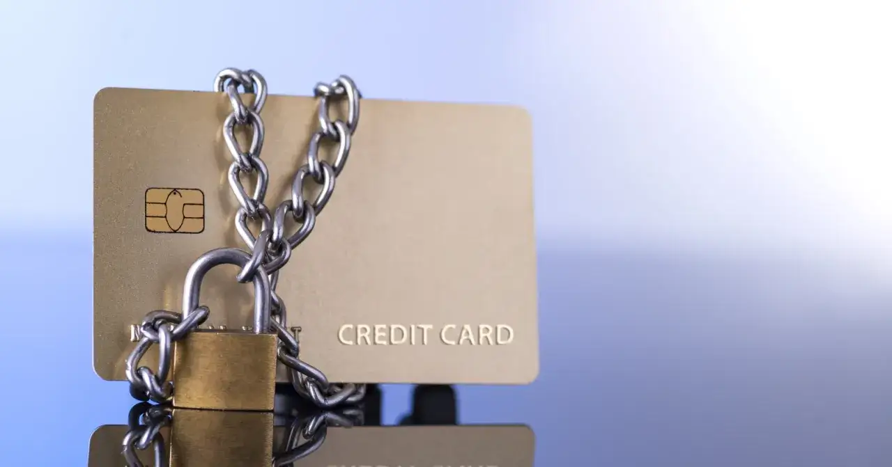 Carte bancaire bloquée, cadenas et chaîne symbolisant un dépassement de découvert.
