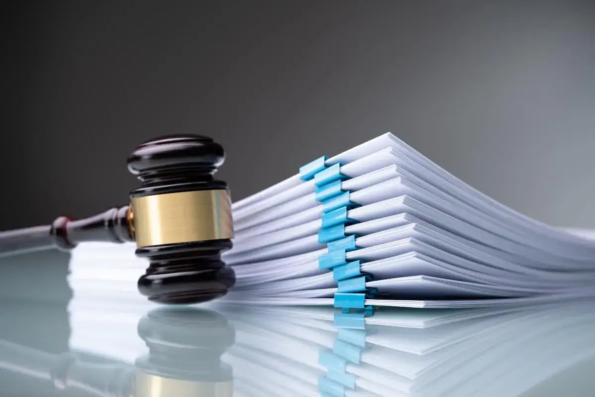Marteau de juge sur une pile de documents, symbolisant un litige pour non-respect du devis par le professionnel.